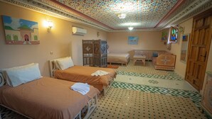 A hotel room with two beds, a sofa, a small table, and a decorative ceiling. - Riad Golden Mansour  (Meknes)