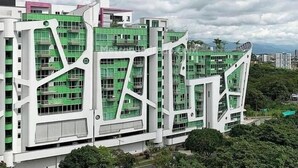 Um edifício moderno de vários andares com design arquitetônico único, destacando um esquema de cores verde e branco.