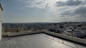 A rooftop terrace with a view of a cityscape and distant mountains. - Villa The Crown  (Ariana)