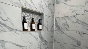 Een douche, handdoeken, zeep, toiletpapier