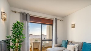 Una sala de estar moderna con un sofá, una mesa y una planta en maceta.