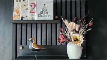 A shelf with books titled 'The Little Book of the Icelanders' and a decorative bird statue.