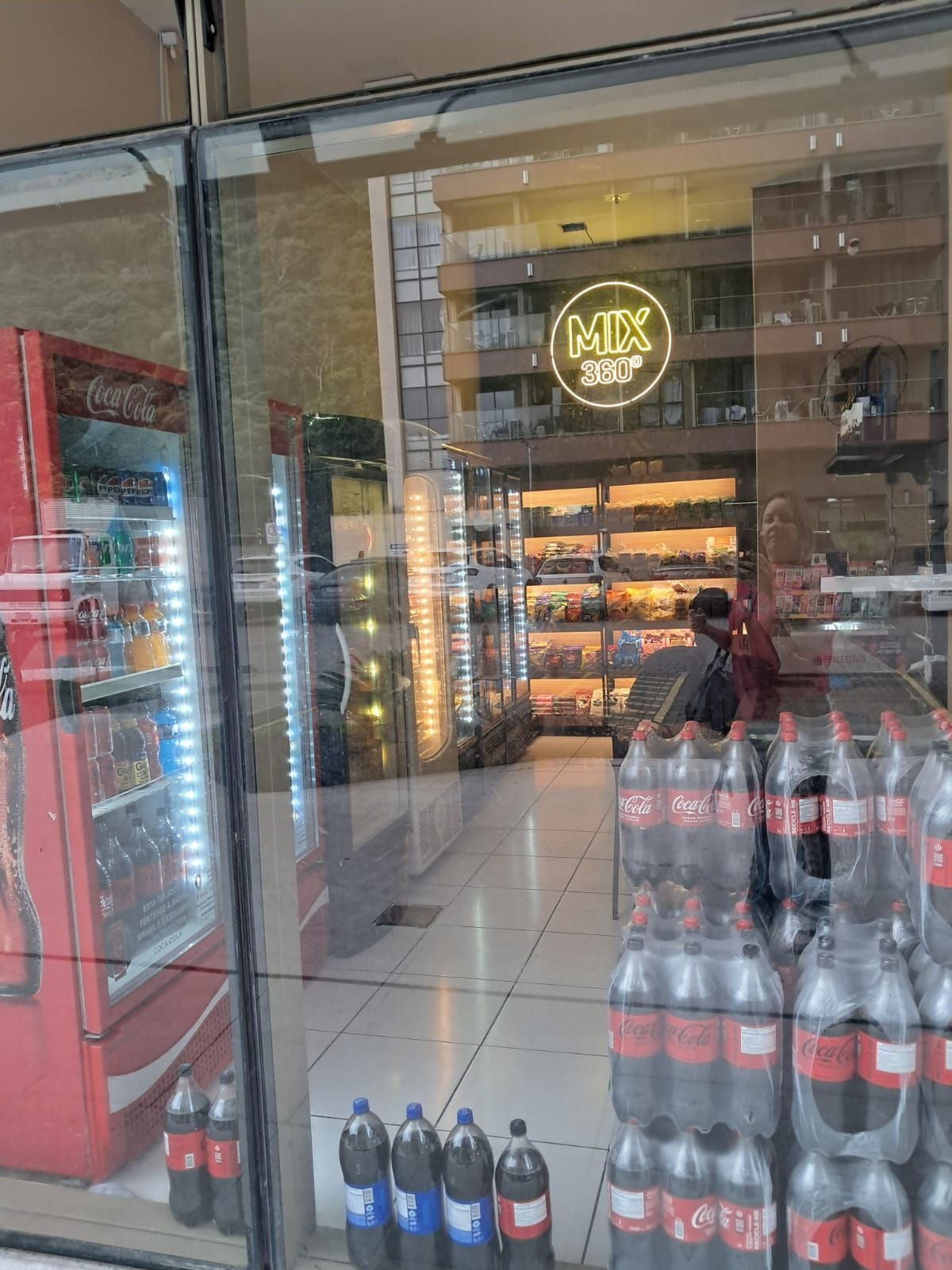 A store with a Coca-Cola vending machine and a display of Coca-Cola bottles.