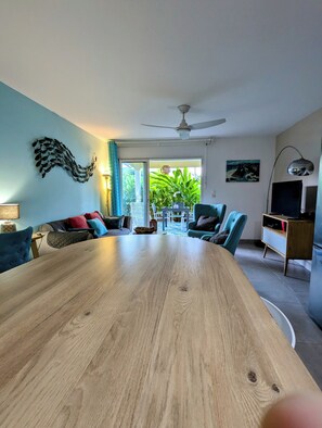 Relax in this stylish living room with a large dining table, comfortable seating, and a beautiful view.