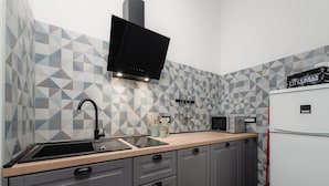 A modern kitchen with a black range hood, a microwave, and a refrigerator. - Apartment With View (Porec)