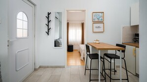 Une cuisine compacte avec un coin repas, un miroir et une citation encadrée accrochée au mur.