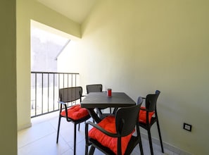 A balcony with a table and chairs, a red cushion on each chair, and a can on the table. - Apartment With Cozy Bedroom (Porec)