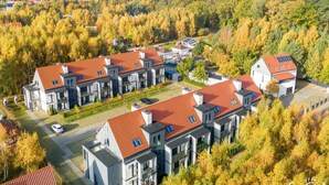 A modern residential complex with multiple buildings, red-tiled roofs, and solar panels. - Studio in Niechorze Near Baltic Beach (Rewal)