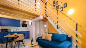 Een modern appartement met een keuken, eethoek en een blauwe bank.