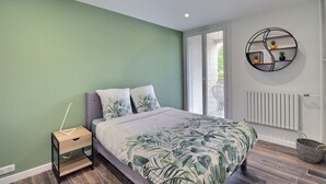 A bedroom with a bed, nightstand, and a wall-mounted shelf with plants. - The Aixoise Escape - Close to the city center (Aix-en-Provence)