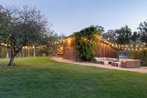 A rustic outdoor seating area with a wooden structure and string lights.