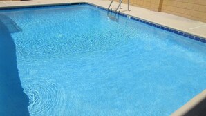Una piscina rettangolare con acqua cristallina e bordo piastrellato.