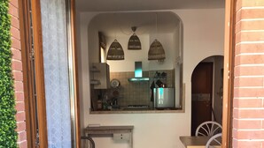 Una cuina compacta amb zona de menjador, taula petita i cadira.