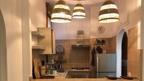 Cuina amb una illa central, forns i nevera. Hi ha llums penjants sobre l'illa.