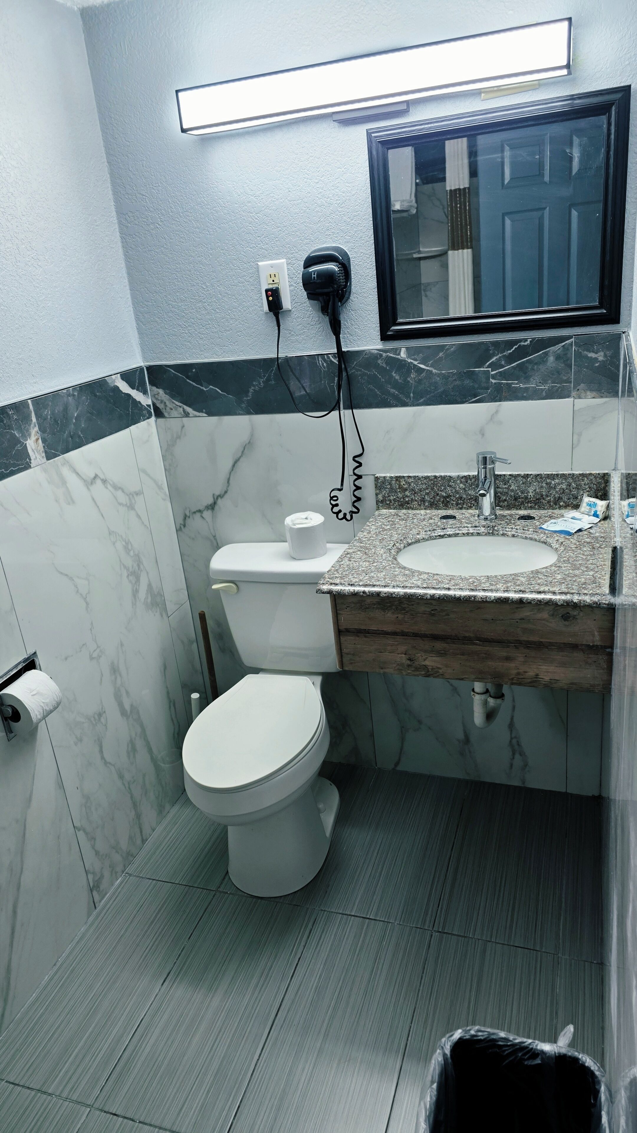 Ein Badezimmer mit Toilette, Waschbecken und Spiegel.
