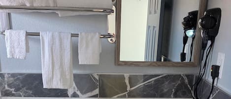 A bathroom with a toilet, sink, and mirror.
