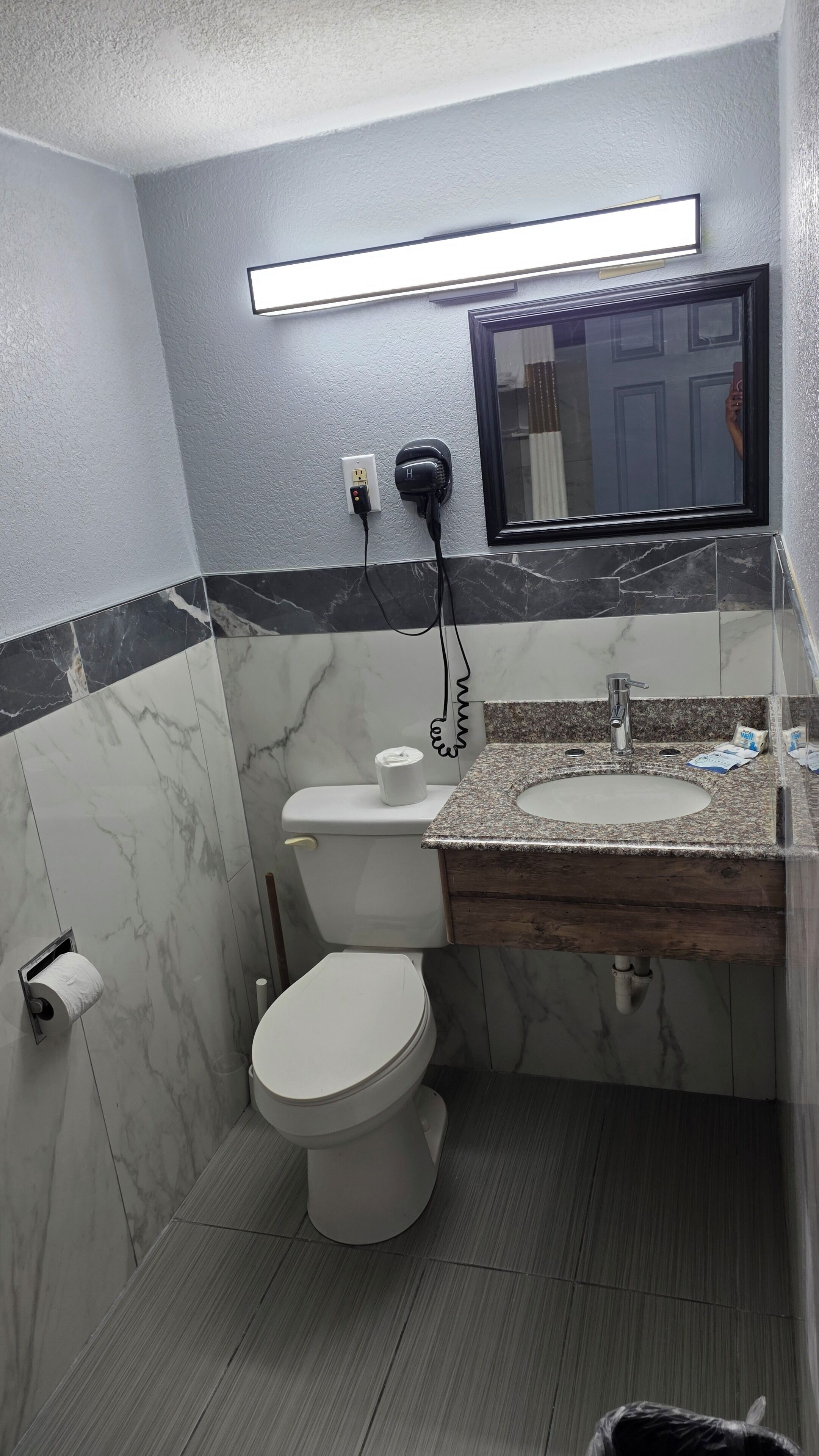 Ein Badezimmer mit Toilette, Waschbecken und Spiegel.