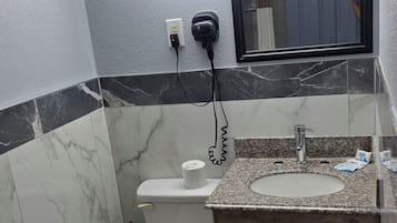 Ein Badezimmer mit Toilette, Waschbecken und Spiegel.