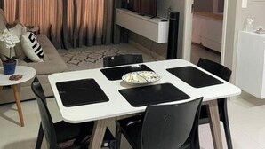 Kompakti oleskelutila, jossa on ruokailualue, sohva, televisio ja pieni keittiö.