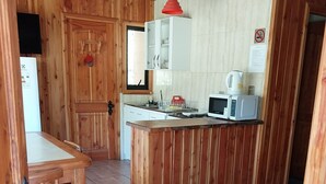 Un intérieur en bois comprenant un coin cuisine, une table à manger et un panneau indiquant le numéro de la chambre : 4.