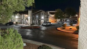 A nighttime view of a street with a building that has a covered entrance and a parking lot. - Contemporary luxurious Condo with Mountain View’s in Henderson . WiFi, Roku TV.  (Henderson)
