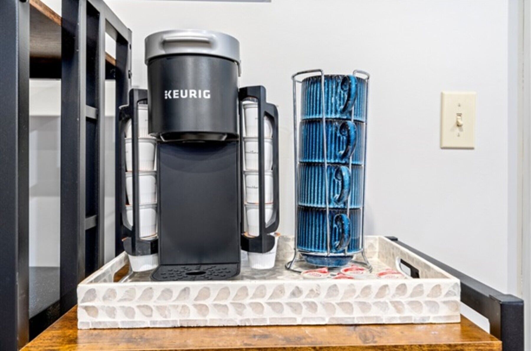 Een Keurig koffieapparaat met een houder voor koffiekapsules op een dienblad.
