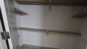 Ett smalt, avgränsat utrymme med ett kaklat golv, en dörr med ett metallhandtag och en metallstång som sitter fast upptill.