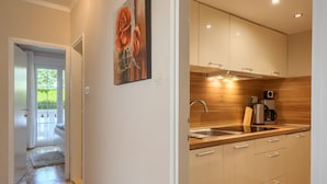 A modern kitchen with a wooden backsplash, stainless steel appliances, and a large window. - Apartment in Porec Near the Sea and Beaches (Porec)