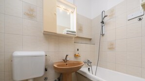 A bathroom with a toilet, sink, and bathtub. - Pretty Apartment With Balcony (Porec)