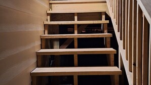 A wooden staircase with a railing, leading to a balcony. - Cozy Cabin by the Lake (Tyler)