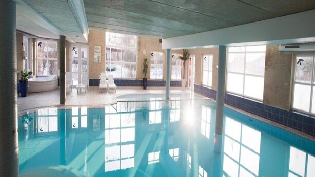 An indoor swimming pool with clear glass walls, allowing natural light to enter. - 2 Person Holiday Park Home in Romo (Rømø)