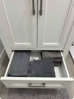 Une armoire blanche à deux portes et un tiroir.