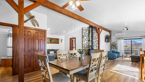 Amplia sala de estar con una mesa de comedor de madera, sillas, un sofá y una chimenea.