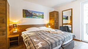 Ein Schlafzimmer mit einem Bett, einem Holzschrank, Nachttischen und einem Bild an der Wand.