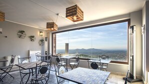 Ein Essbereich mit Panoramablick, ausgestattet mit einem großen Tisch, Stühlen, Holz-Pendelleuchten und einem modernen Interieur.