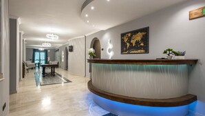 Ein moderner Empfangsbereich mit einer gebogenen Rezeption, einer Weltkarte an der Wand und einem Blumentopf auf der Theke.