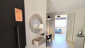 A modern kitchen with a black refrigerator, a wooden countertop, a potted orchid, and a round mirror. - Piante Del Principe Apartments and Rooms (Carini)