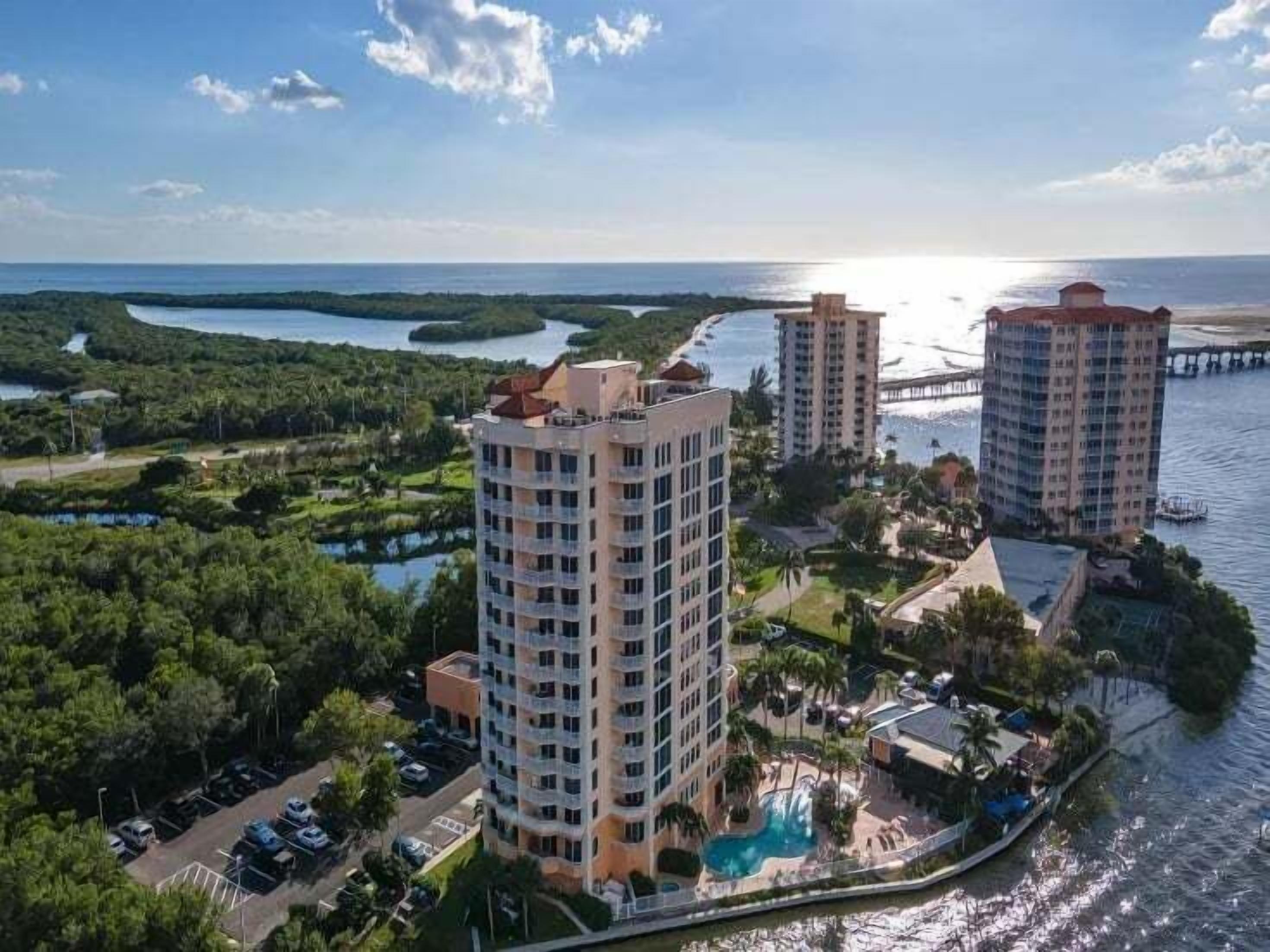 A high-rise hotel with a pool and waterfront views.
