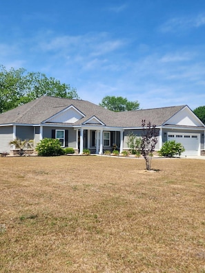 A single-story house with a front porch, a garage, and a well-maintained lawn.