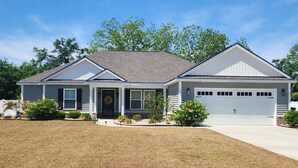 A single-story house with a garage, a front porch, and a well-maintained lawn.