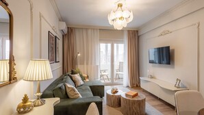 A modern living room with a green sofa, a lamp, a TV, and a large window with curtains. - Parisian-Inspired 1BR in the Heart of Bucharest - Balcony, AC & Fully Equipped (Bucharest)