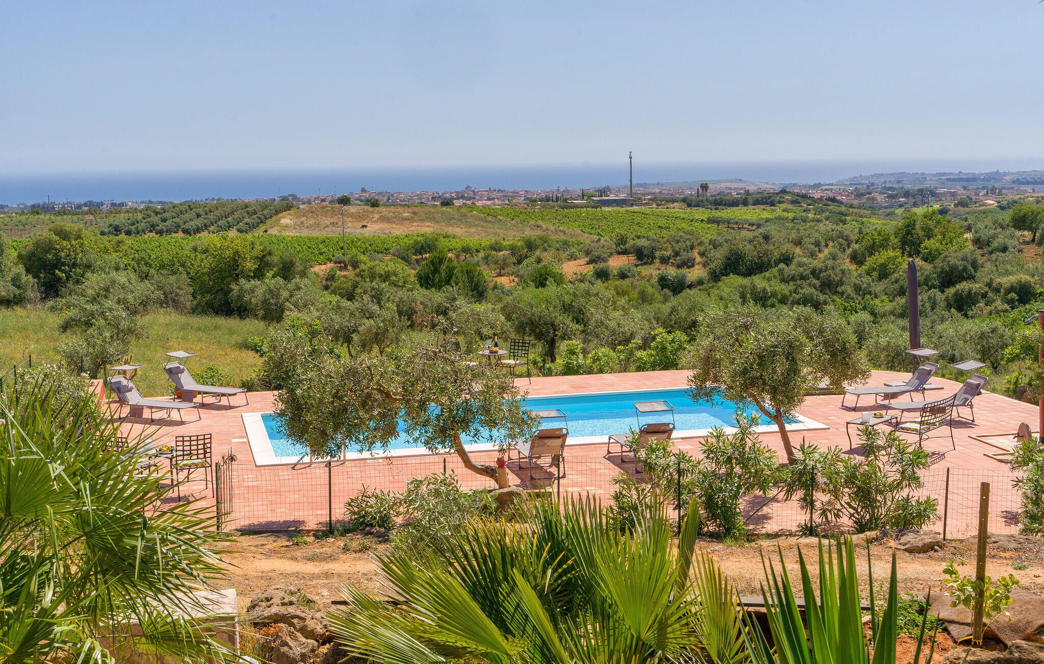 Una piscina con lettini e vista sul mare.
