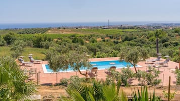 Una piscina con lettini e vista sul mare.