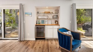 Une cuisine moderne dotée d’un four encastré, d’un plan de travail agrémenté d’objets décoratifs et offrant une vue sur l’extérieur grâce à de grandes portes-fenêtres coulissantes.