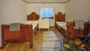 A small, cozy bedroom with two wooden beds, a white dresser, and a window with floral curtains. - 1 bedroom gorgeous home in Svenljunga (Svenljunga)