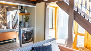 A laundry area with a washing machine, a wooden staircase, and a view of the outside. - Mountain Serenity | Ski, Golf, Casino and Lake within 5 mile (Stateline)