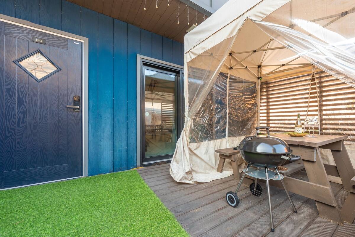 A covered outdoor area with a grill, a tent, and a door marked 'B4'.