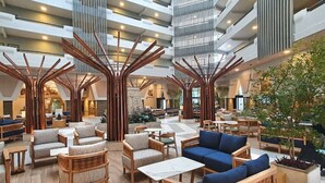 Un'ampia hall con soffitti alti, strutture in legno che ricordano alberi e confortevoli aree salotto.