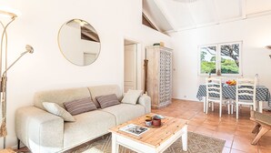 A modern living room with a sofa, coffee table, and dining area. - Parc Oasis by Interhome (Gassin)