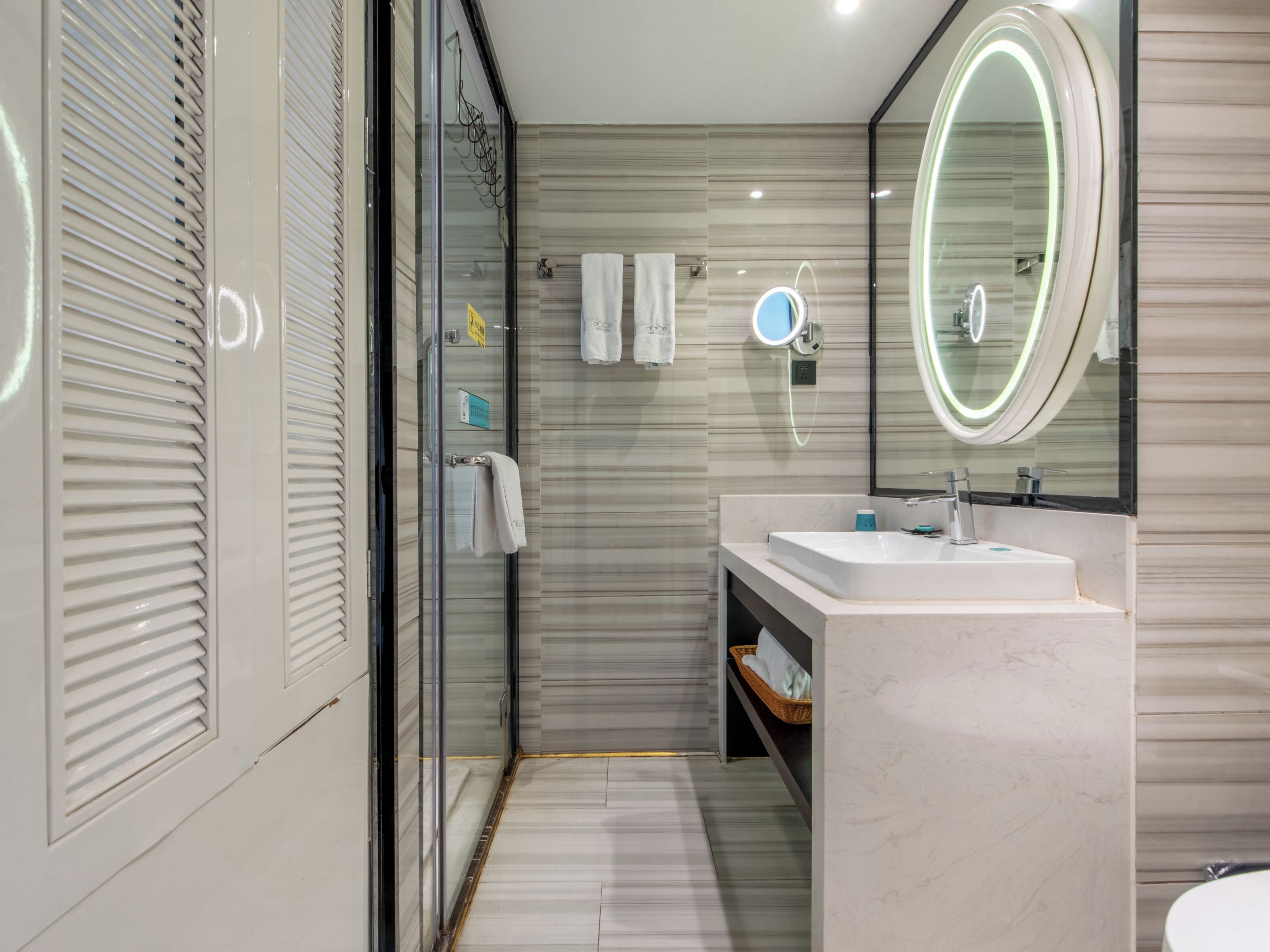 A modern bathroom with a glass shower enclosure, a vanity with a mirror, and a toilet.